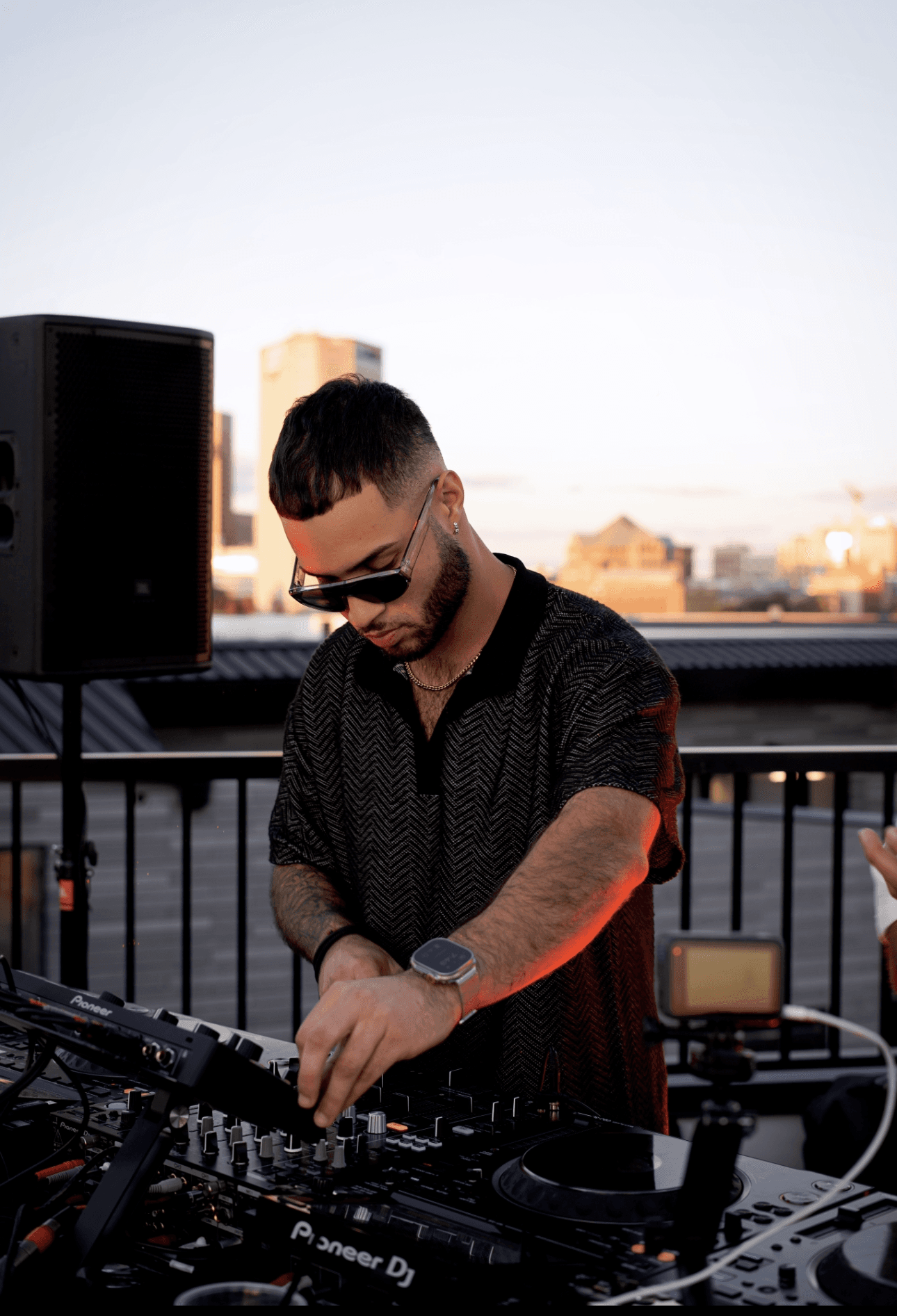 DJ mixing behind laptops under green light